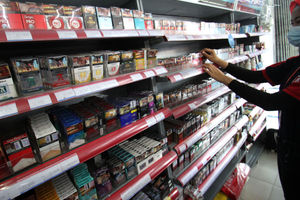 <p>Seorang karyawan tengah menata rokok dari berbagai jenis dan merk di sebuah etalase waralaba kawasan Cengkareng Jakarta Barat, Rabu 17 Maret 2021. Foto: Panji Asmoro/TrenAsia</p>
