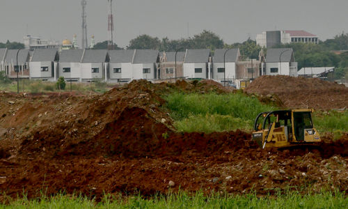 <p>Pekerja dengan alat berat mengerjakan proyek pembangunan rumah di kawasan Cimanggis, Depok, Jawa Barat, Rabu, 17 Maret 2021. Foto: Ismail Pohan/TrenAsia</p>
