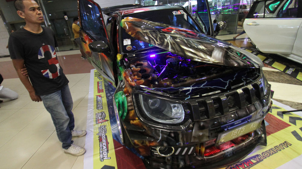 <p>Sejumlah pengunjung mengamati mobil modifikasi yang tengah berlaga dalam Ashar Wheels Auto Contest 2021. Foto: Panji Asmoro/TrenAsia</p>
