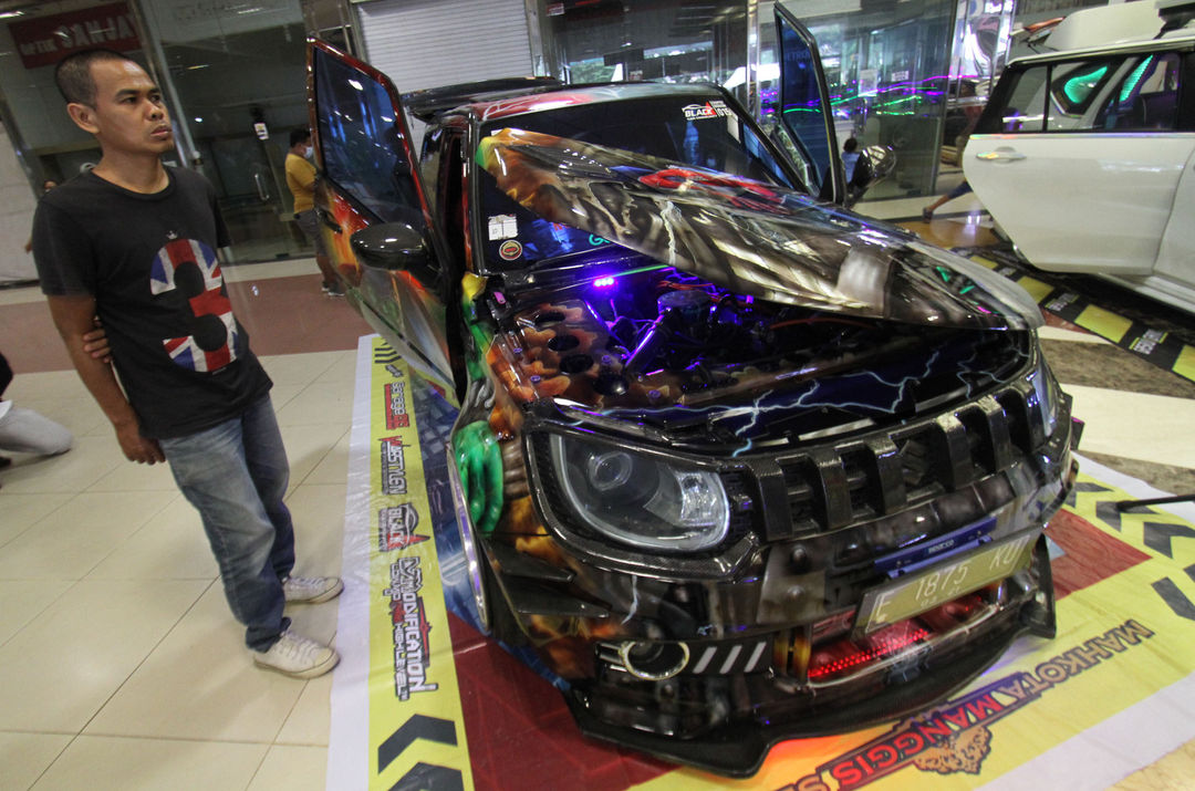 <p>Sejumlah pengunjung mengamati mobil modifikasi yang tengah berlaga dalam Ashar Wheels Auto Contest 2021. Foto: Panji Asmoro/TrenAsia</p>
