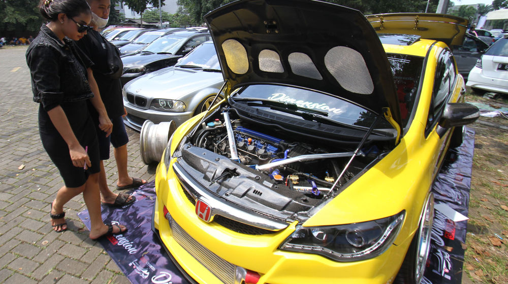 <p>Sejumlah pengunjung mengamati mobil modifikasi yang tengah berlaga dalam Ashar Wheels Auto Contest 2021. Foto: Panji Asmoro/TrenAsia</p>
