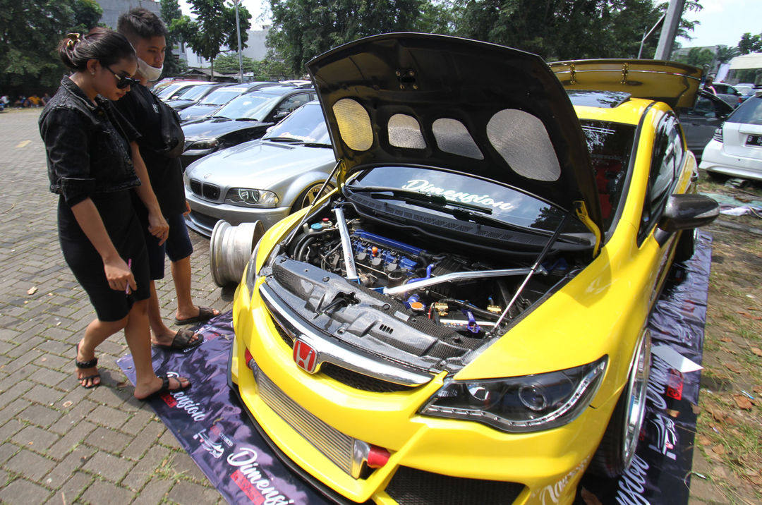 <p>Sejumlah pengunjung mengamati mobil modifikasi yang tengah berlaga dalam Ashar Wheels Auto Contest 2021. Foto: Panji Asmoro/TrenAsia</p>
