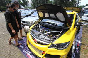 <p>Sejumlah pengunjung mengamati mobil modifikasi yang tengah berlaga dalam Ashar Wheels Auto Contest 2021. Foto: Panji Asmoro/TrenAsia</p>
