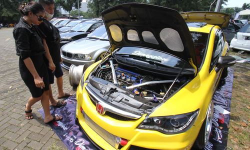 <p>Sejumlah pengunjung mengamati mobil modifikasi yang tengah berlaga dalam Ashar Wheels Auto Contest 2021. Foto: Panji Asmoro/TrenAsia</p>
