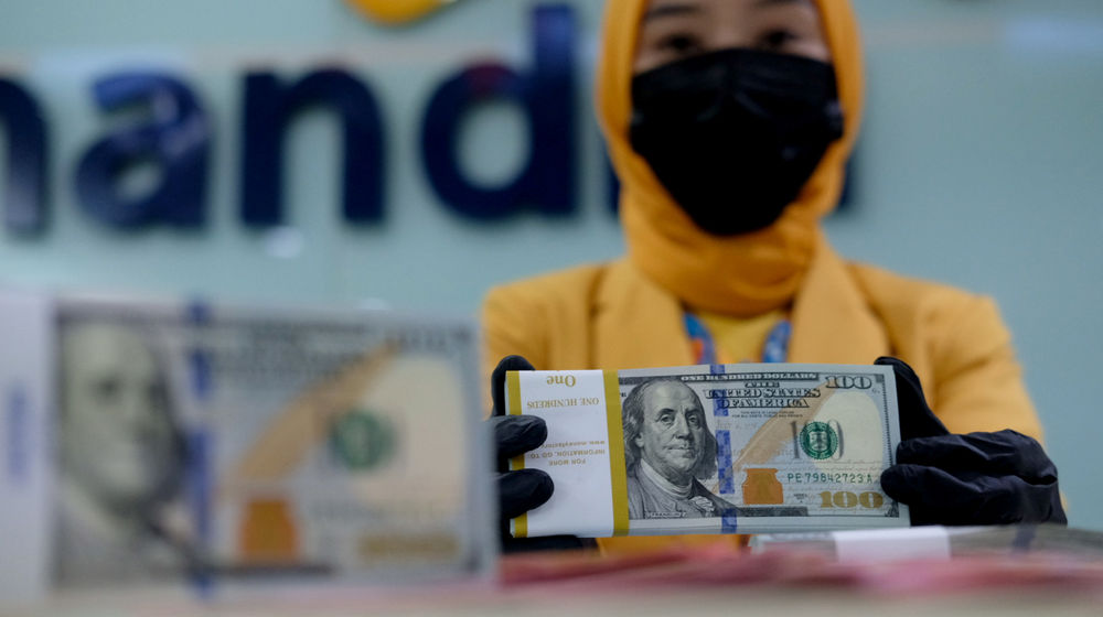 <p>Karyawati menunjukkan mata uang dolar di kantor cabang Bank Mandiri, Jakarta, Senin, 22 Maret 2021. Foto: Ismail Pohan/TrenAsia</p>
