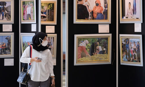 <p>Pengunjung menyaksikan pameran foto bertajuk “Kiprah Perempuan Parlemen: Jalan Harapan Bangsa” dalam rangka peringatan Hari Perempuan Internasional, di selasar Gedung Nusantara II, Kompleks Parlemen, Senayan, Senin, 8 Maret 2021. Foto: Ismail Pohan/TrenAsia</p>
