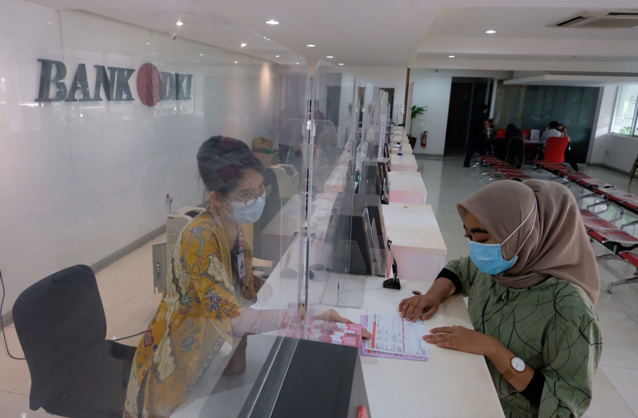 <p>Karyawan melayani nasabah di salah satu Kantor Cabang Bank DKI, Jakarta, Jum&#8217;at, 26 Maret 2021. Foto: Ismail Pohan/TrenAsia</p>
