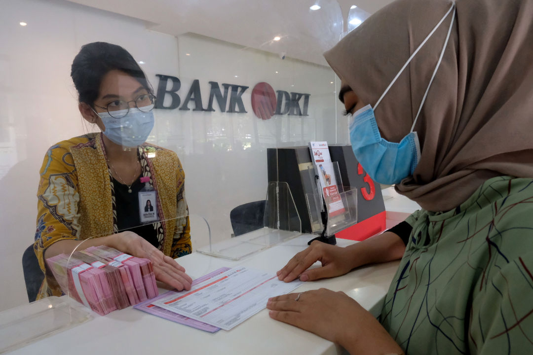 <p>Karyawan melayani nasabah di salah satu Kantor Cabang Bank DKI, Jakarta, Jum&#8217;at, 26 Maret 2021. Foto: Ismail Pohan/TrenAsia</p>
