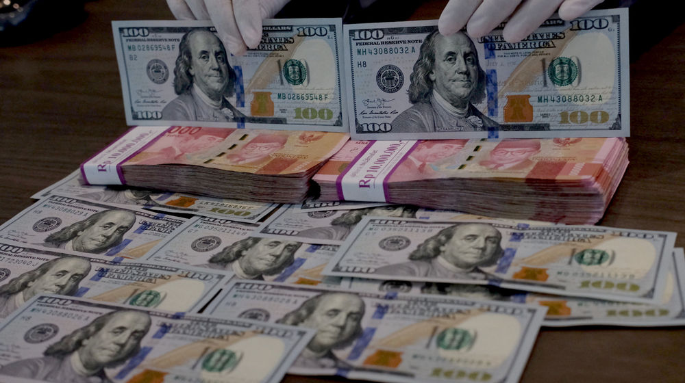 <p>Karyawati menunjukkan mata uang Dolar Amerika dan Rupiah di salah satu teller bank, di Jakarta, Rabu, 3 Maret 2021. Foto: Ismail Pohan/TrenAsia</p>
