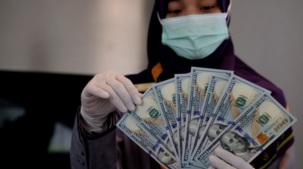 <p>Karyawati menunjukkan mata uang Dolar Amerika di salah satu teller bank, di Jakarta, Rabu, 3 Maret 2021. Foto: Ismail Pohan/TrenAsia</p>
