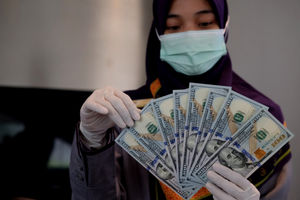 <p>Karyawati menunjukkan mata uang Dolar Amerika di salah satu teller bank, di Jakarta, Rabu, 3 Maret 2021. Foto: Ismail Pohan/TrenAsia</p>
