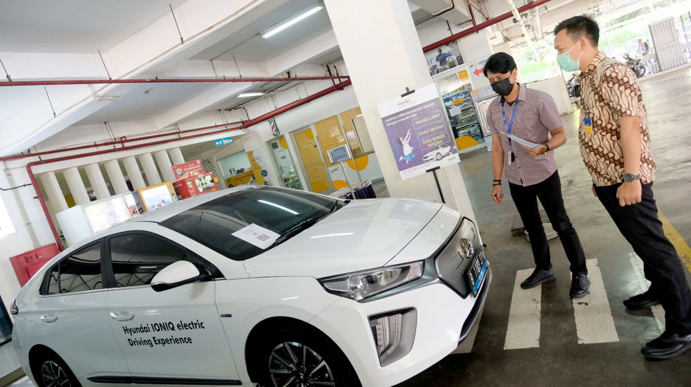 <p>Karyawan melayani konsumen yang bertanya mengenai pembiayaan pembelian mobil listrik di stan Mandiri Tunas Finance di Jakarta, Selasa, 23 Maret 2021. Foto: Ismail Pohan/TrenAsia</p>
