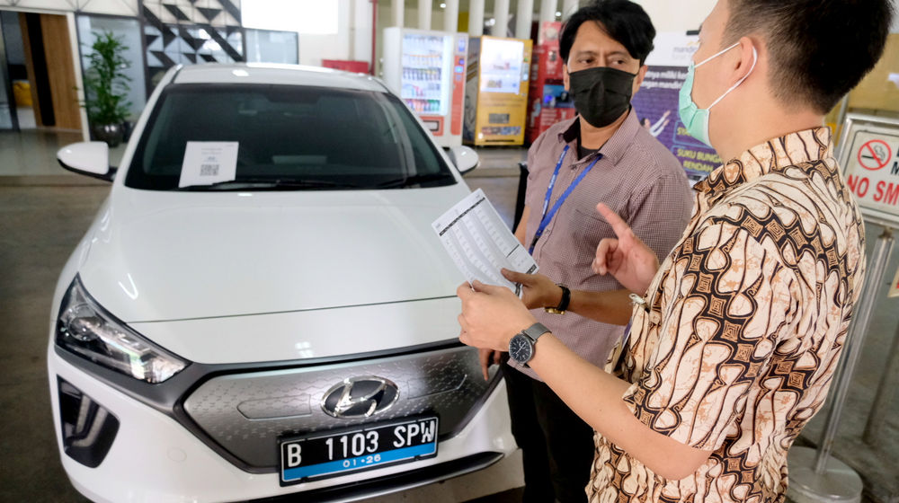 <p>Karyawan melayani konsumen yang bertanya mengenai pembiayaan pembelian mobil listrik di stan Mandiri Tunas Finance di Jakarta, Selasa, 23 Maret 2021. Foto: Ismail Pohan/TrenAsia</p>

