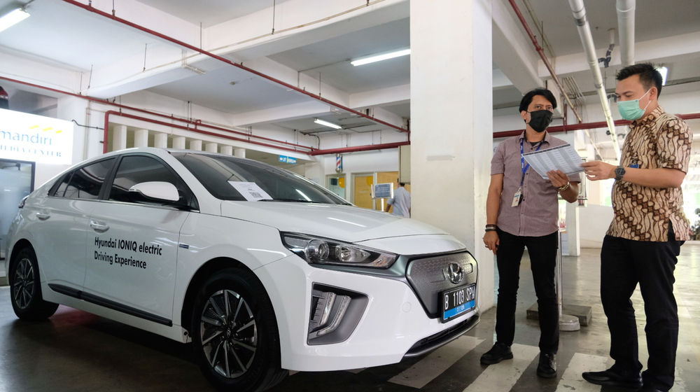 <p>Karyawan melayani konsumen yang bertanya mengenai pembiayaan pembelian mobil listrik di stan Mandiri Tunas Finance di Jakarta, Selasa, 23 Maret 2021. Foto: Ismail Pohan/TrenAsia</p>
