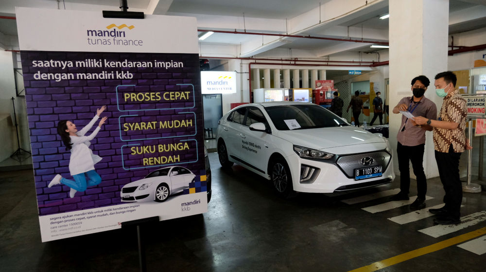 <p>Karyawan melayani konsumen yang bertanya mengenai pembiayaan pembelian mobil listrik di stan Mandiri Tunas Finance di Jakarta, Selasa, 23 Maret 2021. Foto: Ismail Pohan/TrenAsia</p>
