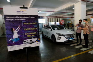 <p>Karyawan melayani konsumen yang bertanya mengenai pembiayaan pembelian mobil listrik di stan Mandiri Tunas Finance di Jakarta, Selasa, 23 Maret 2021. Foto: Ismail Pohan/TrenAsia</p>
