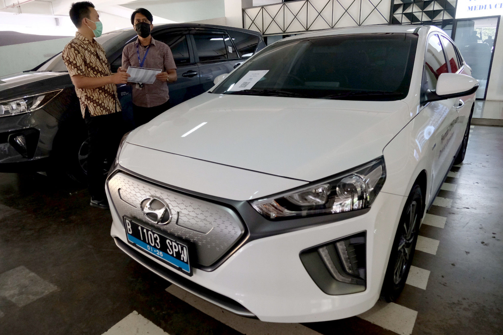 <p>Karyawan melayani konsumen yang bertanya mengenai pembiayaan pembelian mobil listrik di stan Mandiri Tunas Finance di Jakarta, Selasa, 23 Maret 2021. Foto: Ismail Pohan/TrenAsia</p>
