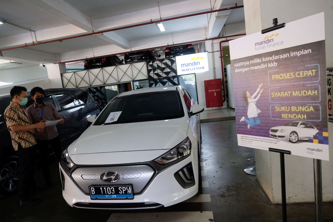 <p>Karyawan melayani konsumen yang bertanya mengenai pembiayaan pembelian mobil listrik di stan Mandiri Tunas Finance di Jakarta, Selasa, 23 Maret 2021. Foto: Ismail Pohan/TrenAsia</p>
