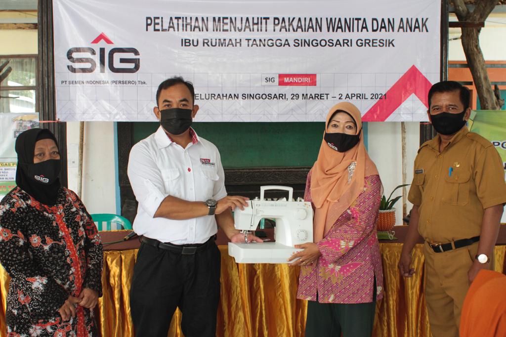 General Manager of CSR SIG, Edy Saraya (dua dari kiri) menyerahkan bantuan mesin jahit kepada salah satu peserta pelatihan menjahit di Singosari, Gresik.