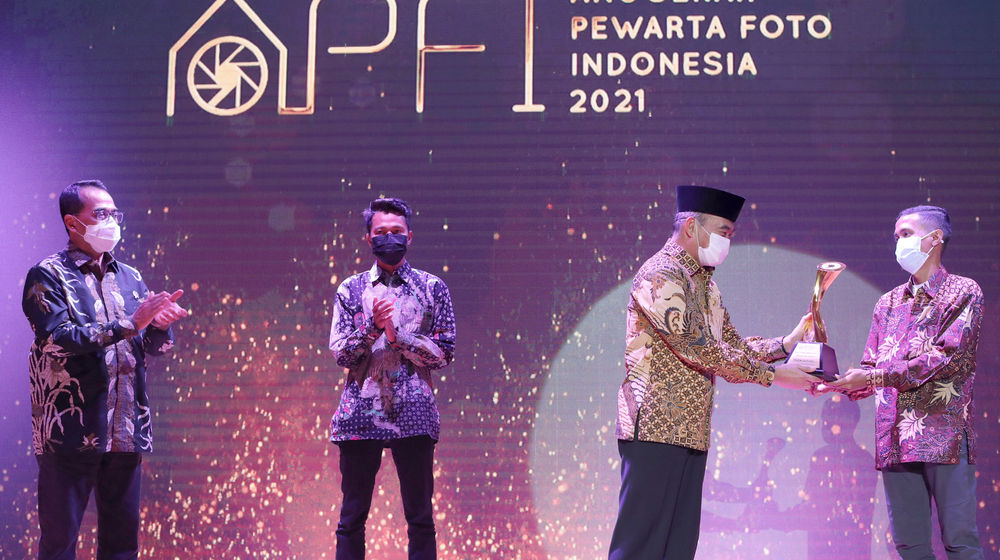 <p>Menteri Kordinator Pembangunan Manusia dan Kebudayaan (Menko PMK), Muhadjir Effendy (kedua kanan) menyerahkan Alex dan Frans Mendur Trophy kepada Pemenang Photo Of The Year 2019, Mugni Supardi (kanan) disaksikan Menteri Perhubungan, Budi Karya Sumadi (kiri) dan Pemenang Photo Of The Year 2020, Givo Alputra (kedua kiri) pada Ajang Penghargaan Anugerah Pewarta Foto Indonesia (APFI) 2021 di Gedung Perpustakaan Nasional, Jalan Merdeka Selatan, Jakarta, Jum’at, 2 April 2021. Foto: dok.PFI</p>
