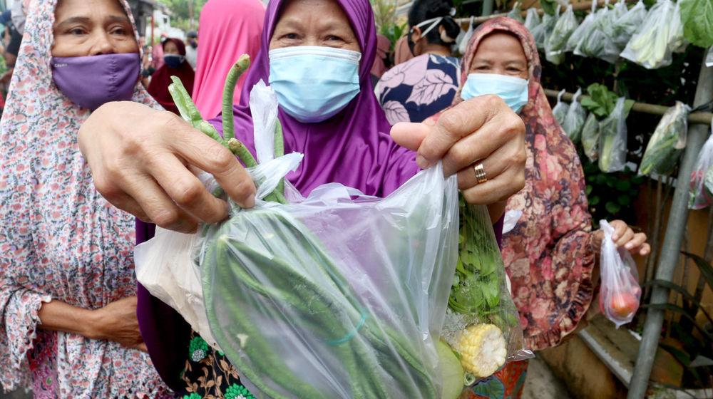 <p>Warga menunjukkan bahan makanan sayuran dan lauk pauk yang diperoleh secara cuma- cuma di bazar warga RW.04 Jalan Jati Padang VI, Jakarta Selatan, Rabu, 28 April 2021. Foto: Ismail Pohan/TrenAsia</p>
