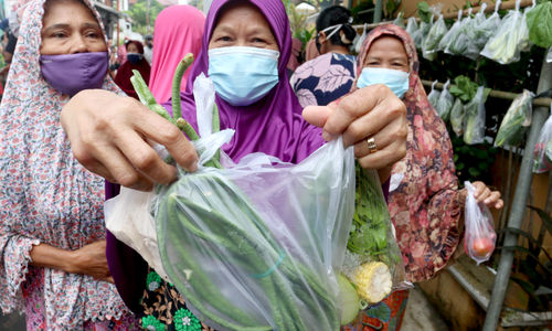 <p>Warga menunjukkan bahan makanan sayuran dan lauk pauk yang diperoleh secara cuma- cuma di bazar warga RW.04 Jalan Jati Padang VI, Jakarta Selatan, Rabu, 28 April 2021. Foto: Ismail Pohan/TrenAsia</p>
