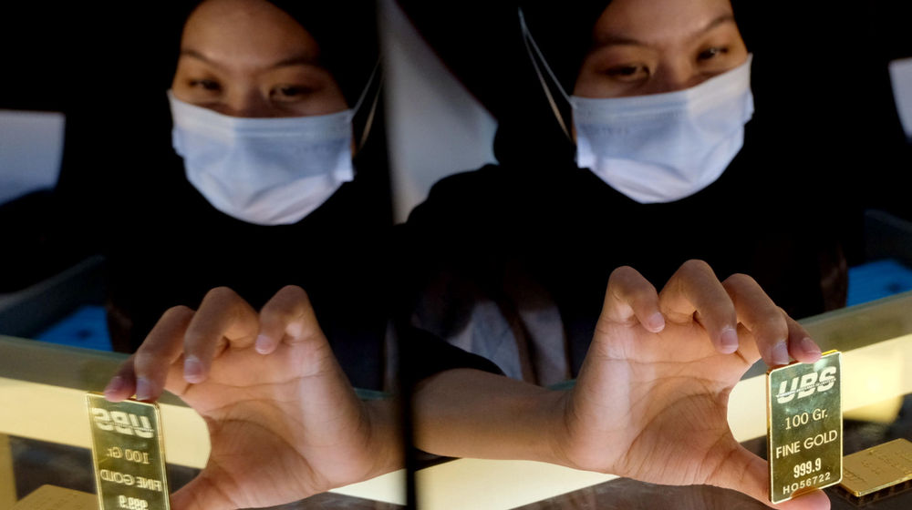 <p>Karyawati menunjukkan emas batangan di gerai Galery 24, Pegadaian, Jakarta, Senin, 5 April 2021. Foto: Ismail Pohan/TrenAsia</p>
