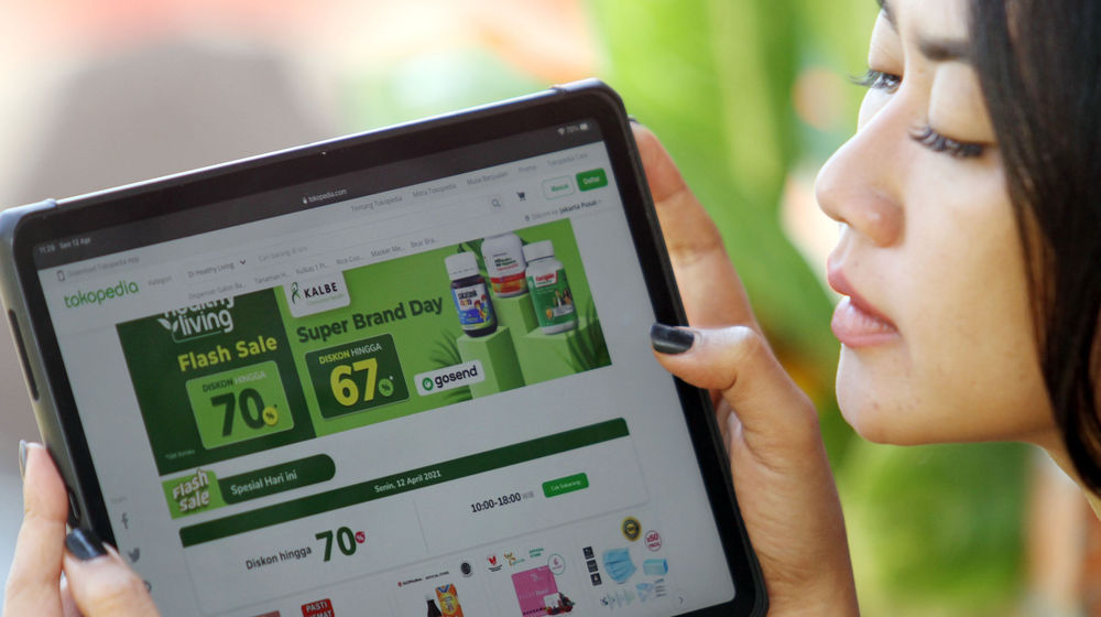 Nampak seorang pelanggan tengah melakukan transaksi melalui aplikasi Tokopedia dengan promo pengantaran dari aplikasi Gosend, PT Gojek Indonesia dan PT Tokopedia dikabarkan tengah mencari kesepakatan untuk melakukan merger. 