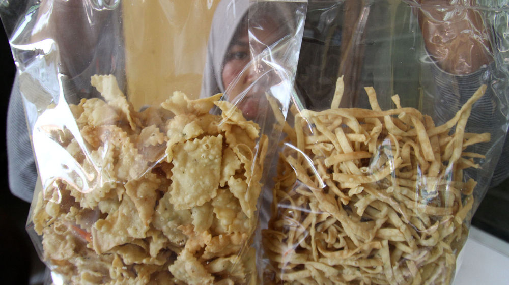 <p>Keluarga Asroni tengah menyelesaikan pesanan pembuatan kue tradisional biji ketapang di kawasan Buaran,Serpong,Tangerang Selatan, Sabtu 24 April 2021. Foto : Panji Asmoro/TrenAsia</p>
