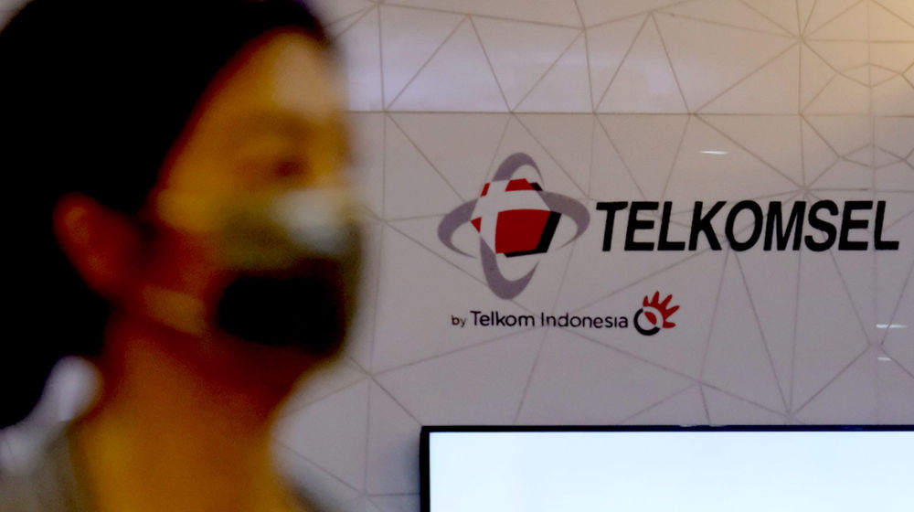 Pelanggan melintas di dekat logo Telkomsel di gerai GraPARI Telkomsel yang berada di salah satu pusat perbelanjaan di Jakarta, Senin, 19 April 2021.
