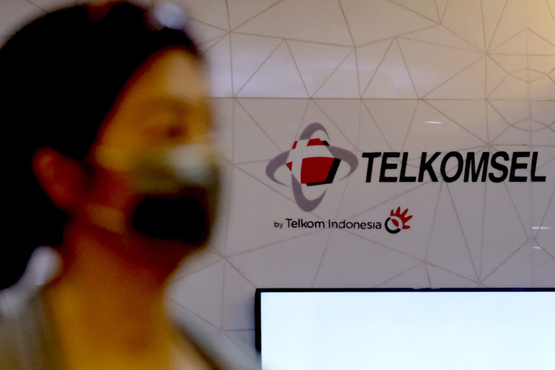 Pelanggan melintas di dekat logo Telkomsel di gerai GraPARI Telkomsel yang berada di salah satu pusat perbelanjaan di Jakarta, Senin, 19 April 2021.