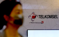 Pelanggan melintas di dekat logo Telkomsel di gerai GraPARI Telkomsel yang berada di salah satu pusat perbelanjaan di Jakarta, Senin, 19 April 2021.