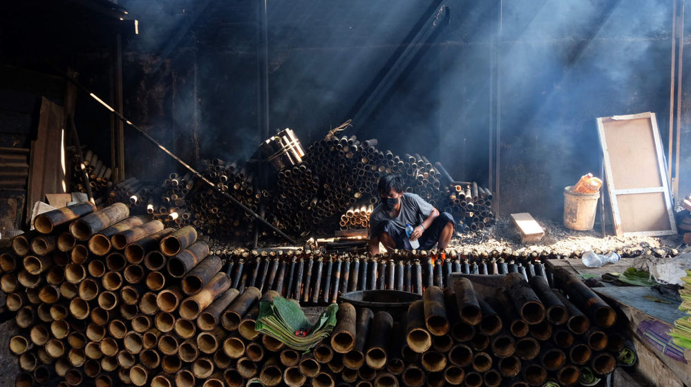 <p>Pekerja membakar lemang yang sudah dibungkus daun pisang dan dimasukkan ke dalam bambu di industri pembuatan lemang kawasan Senen, Jakarta, Selasa, 27 April 2021. Foto: Ismail Pohan/TrenAsia</p>
