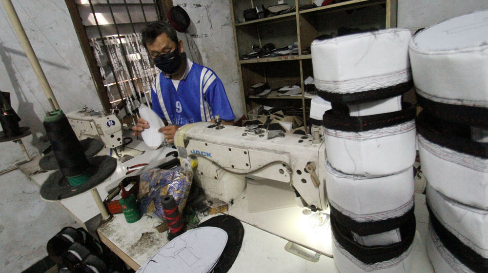 <p>Pengrajin songkok (peci) sedang mengerjakan pesanan berbagai jenis peci di kawasan Pasar Kemis, Kabupaten Tangerang, Minggu 25 April 2021. Foto : Panji Asmoro/TrenAsia</p>
