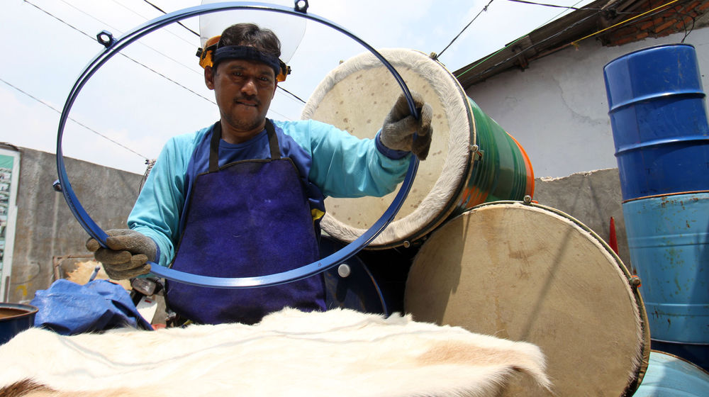 <p>Seorang perajin bedug tengah menyelesaikan pesanan pelanggan di kawasan Pondok Aren Tangerang Selatan , Jumat 17 April 2021. Foto : Panji Asmoro/TrenAsia</p>
