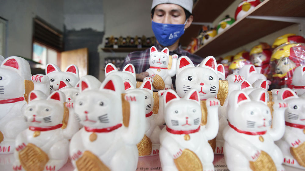 <p>Perajin tengah menyelesaikan pembuatan celengan karakter di kawasan Pondok Cabe Tangerang Selatan, Minggu 11 April 2021. Foto : Panji Asmoro/TrenAsia</p>
