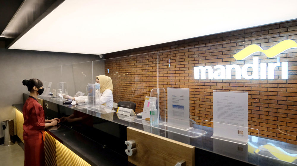 <p>Karyawan melayani nasabah di gerai salah satu cabang Bank Mandiri, di Jakarta, Selasa, 6 April 2021. Foto: Ismail Pohan/TrenAsia</p>
