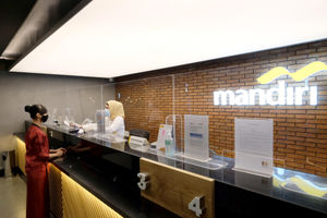 <p>Karyawan melayani nasabah di gerai salah satu cabang Bank Mandiri, di Jakarta, Selasa, 6 April 2021. Foto: Ismail Pohan/TrenAsia</p>
