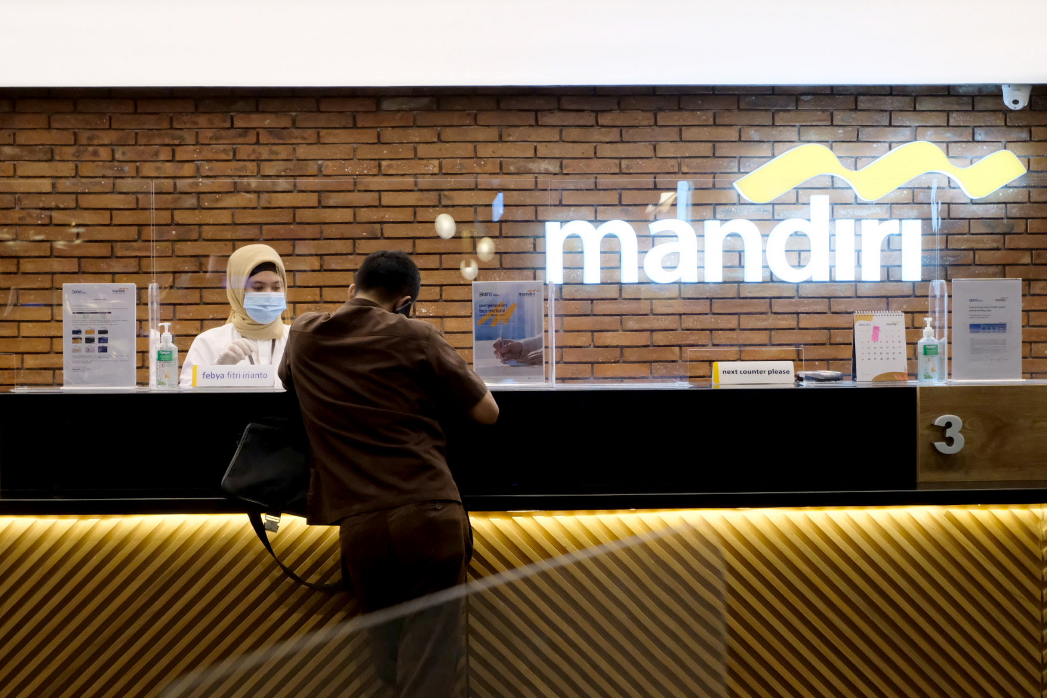 <p>Karyawan melayani nasabah di gerai salah satu cabang Bank Mandiri, di Jakarta, Selasa, 6 April 2021. Foto: Ismail Pohan/TrenAsia</p>
