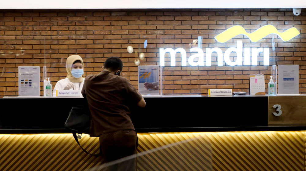 <p>Karyawan melayani nasabah di gerai salah satu cabang Bank Mandiri, di Jakarta, Selasa, 6 April 2021. Foto: Ismail Pohan/TrenAsia</p>
