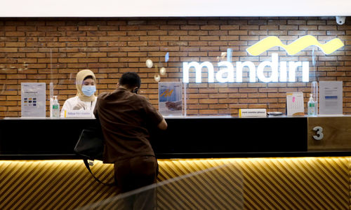 <p>Karyawan melayani nasabah di gerai salah satu cabang Bank Mandiri, di Jakarta, Selasa, 6 April 2021. Foto: Ismail Pohan/TrenAsia</p>
