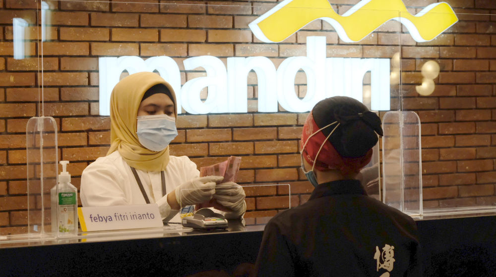 <p>Karyawan melayani nasabah di gerai salah satu cabang Bank Mandiri, di Jakarta, Selasa, 6 April 2021. Foto: Ismail Pohan/TrenAsia</p>