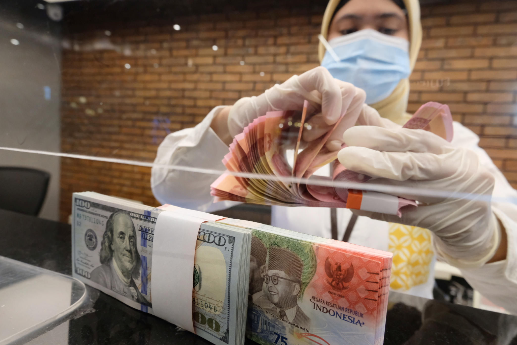 <p>Karyawati menghitung uang di gerai salah satu cabang Bank Mandiri, di Jakarta, Selasa, 6 April 2021. Foto: Ismail Pohan/TrenAsia</p>

