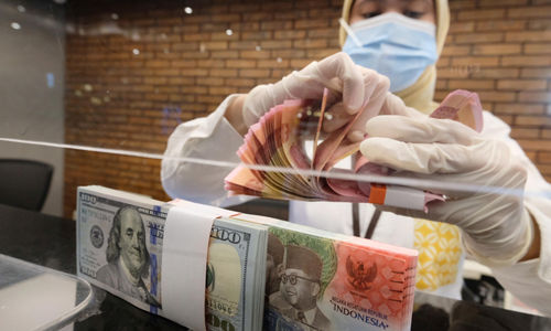 <p>Karyawati menghitung uang di gerai salah satu cabang Bank Mandiri, di Jakarta, Selasa, 6 April 2021. Foto: Ismail Pohan/TrenAsia</p>

