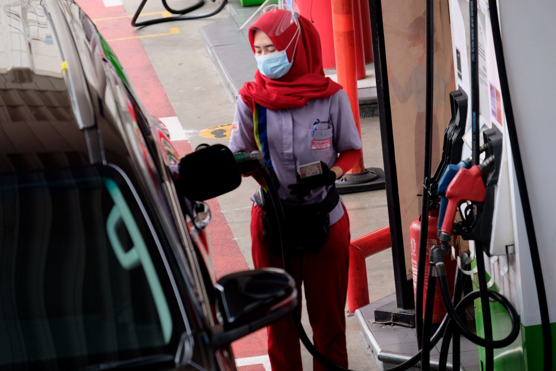 <p>Karyawan melayani pelanggan mengisi bahan bakar kendaraan bermotor di Stasiun Pengisian Bahan Bakar Umum (SPBU) Pertamina, Jalan Rasuna Said, Kuningan, Jakarta, Selasa, 13 April 2021. Foto: Ismail Pohan/TrenAsia</p>
