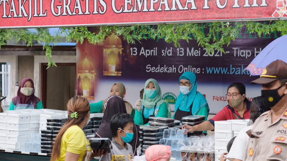 <p>Warga membawa kotakan takjil yang diberikan secara gratis di kawasan Jalan Cempaka Putih Tengah 21, Jakarta Pusat, Kamis, 15 April 2021. Foto: Ismail Pohan/TrenAsia</p>
