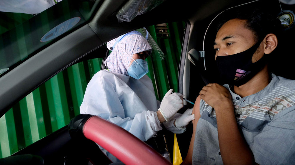 <p>Petigas menyuntikkan dosis vaksin kepada driver Gocar pada vaksinasasi untuk mitra driver Gojek di Kemayoran, Jakarta, Kamis, 29 April 2021. Foto: Ismail Pohan/TrenAsia</p>