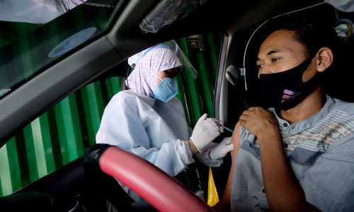 <p>Petigas menyuntikkan dosis vaksin kepada driver Gocar pada vaksinasasi untuk mitra driver Gojek di Kemayoran, Jakarta, Kamis, 29 April 2021. Foto: Ismail Pohan/TrenAsia</p>
