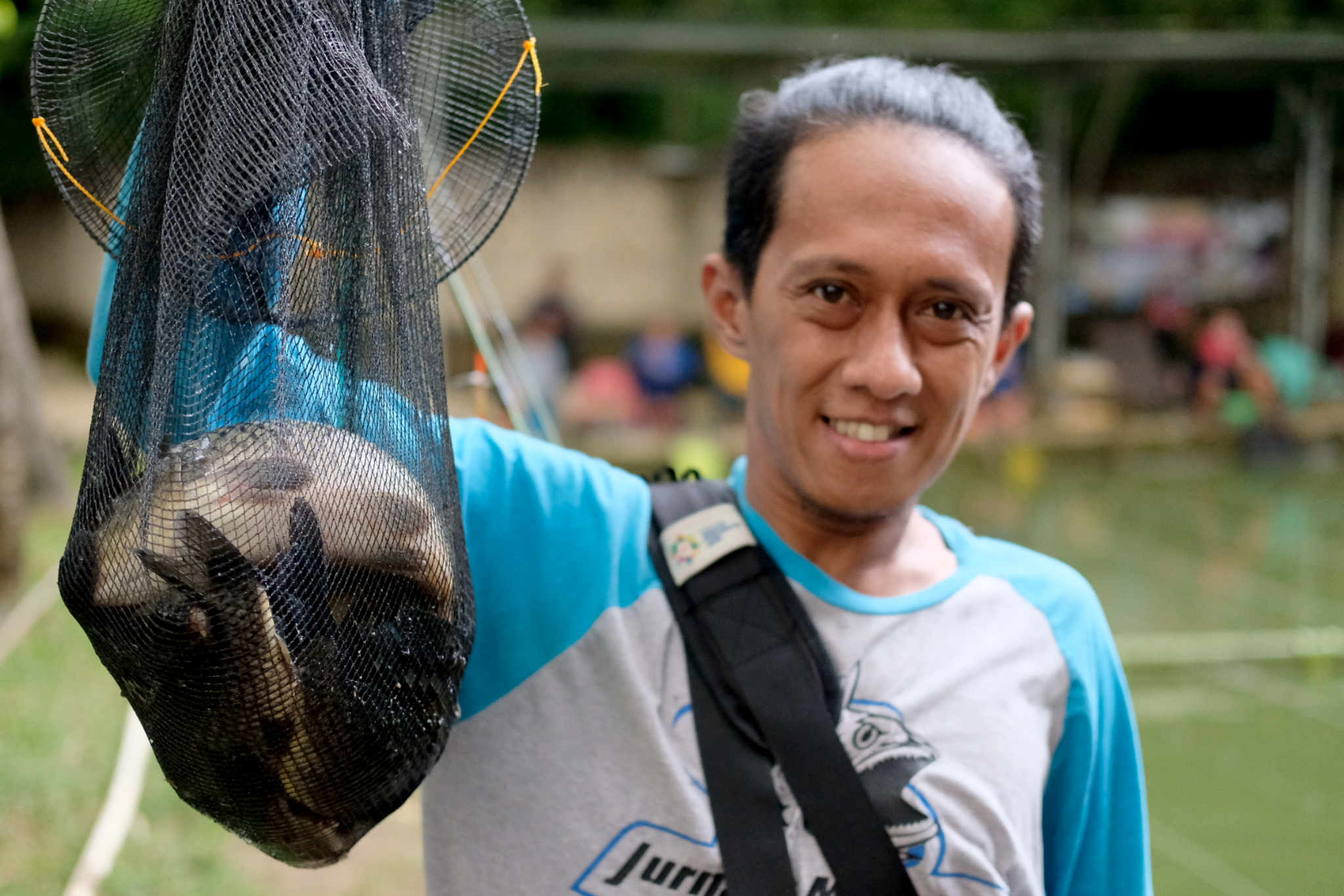 Pemancing memamerkan hasil tanglapannya.