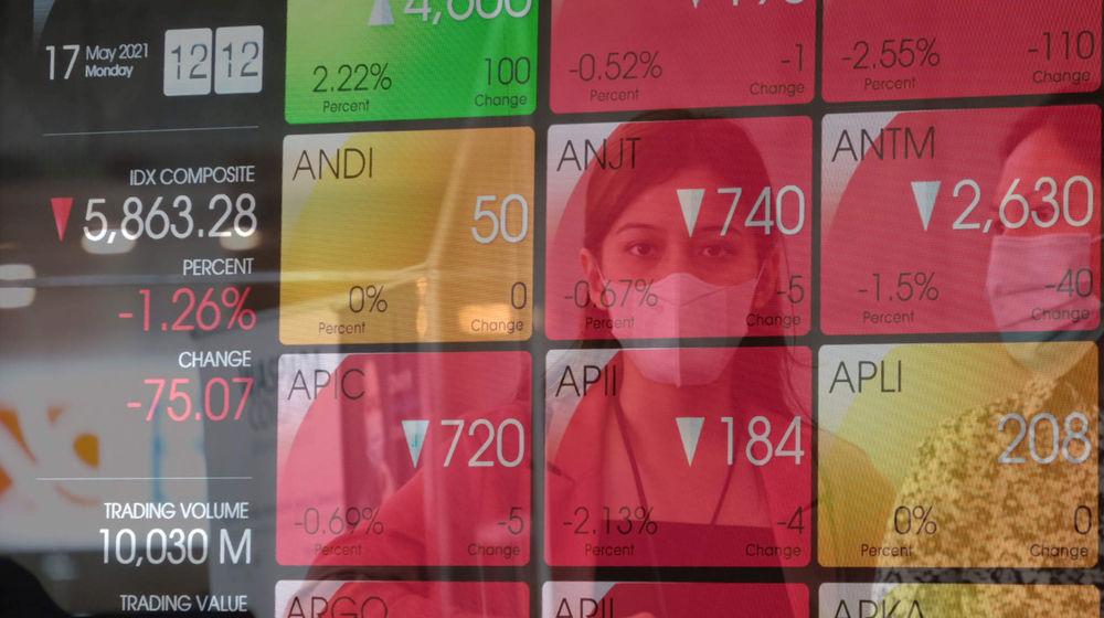 <p>Karyawan melintas dengan latar layar pergerakan indeks harga saham gabungan (IHSG) di gedung Bursa Efek Indonesia (BEI), Jakarta, Senin, 17 Mei 2021. Foto: Ismail Pohan/TrenAsia</p>
